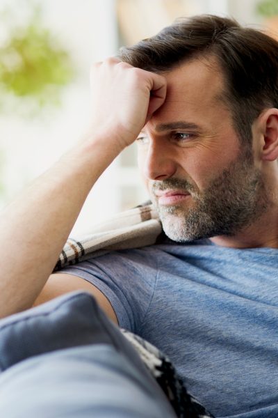 Man feeling discomfort while sitting at home